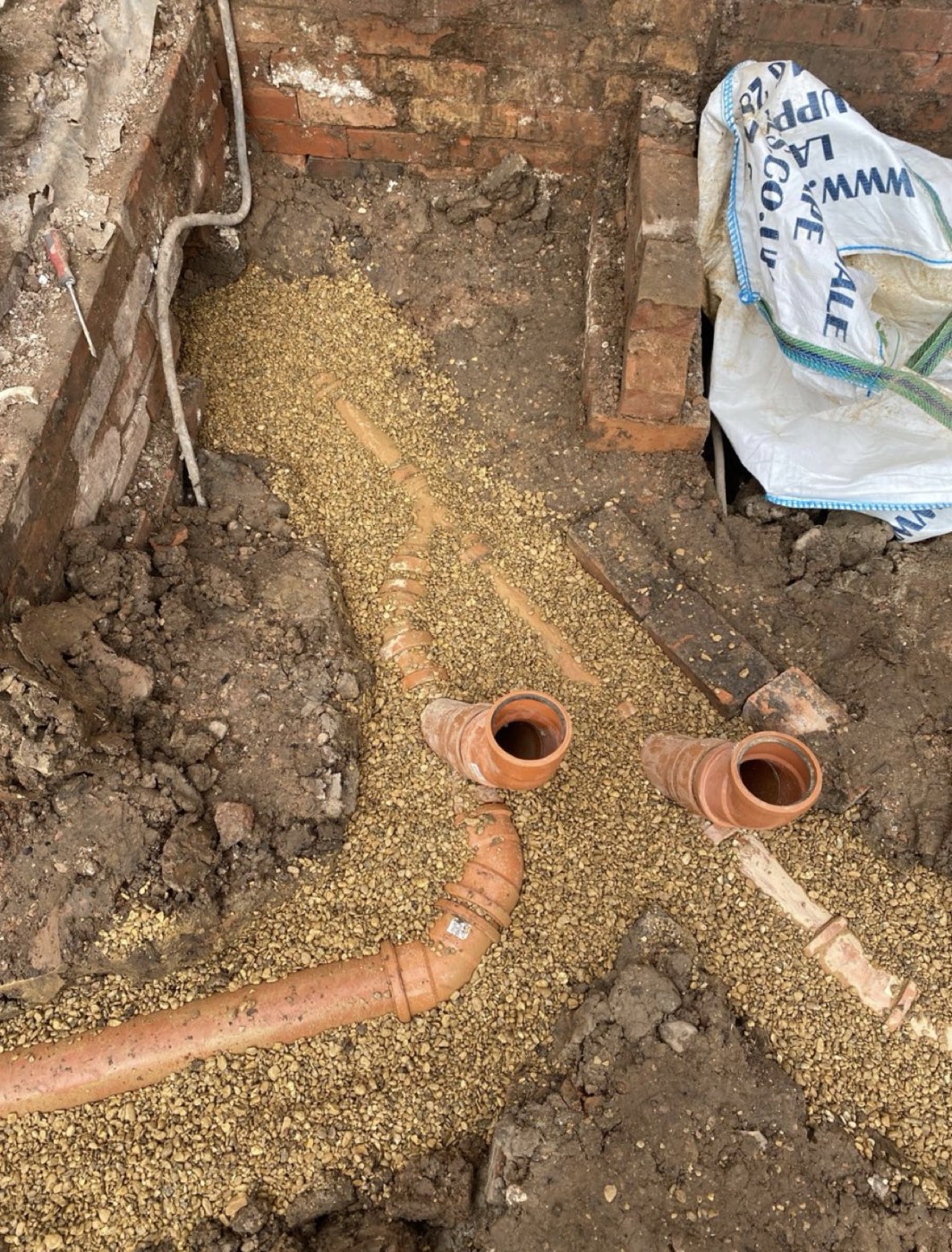 New drainage run bedded in pea gravel
