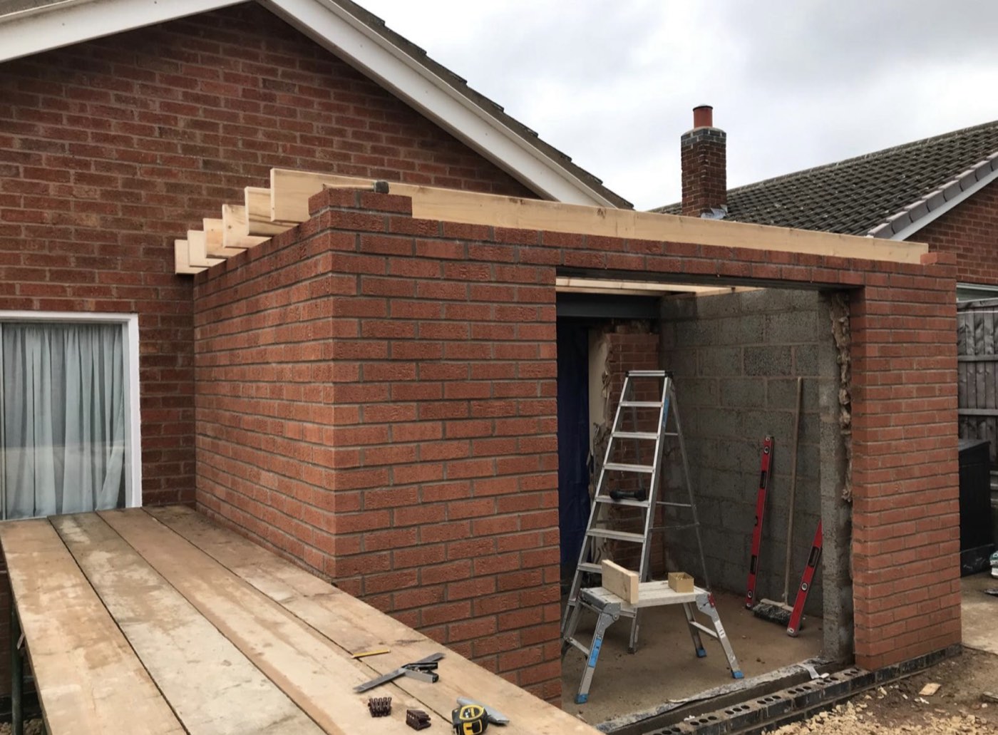 Brickwork and roof timbers going up on a new build